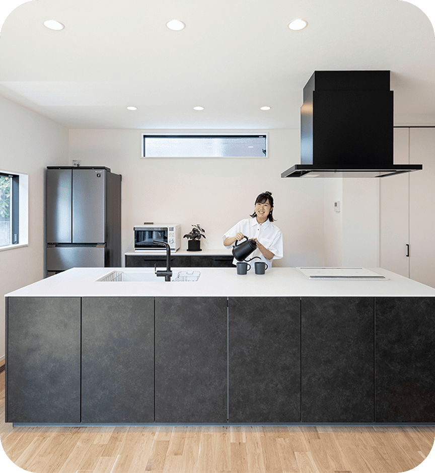 広々としたキッチンでお湯を入れる女性