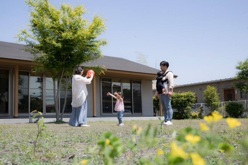 平屋の庭で遊ぶ家族