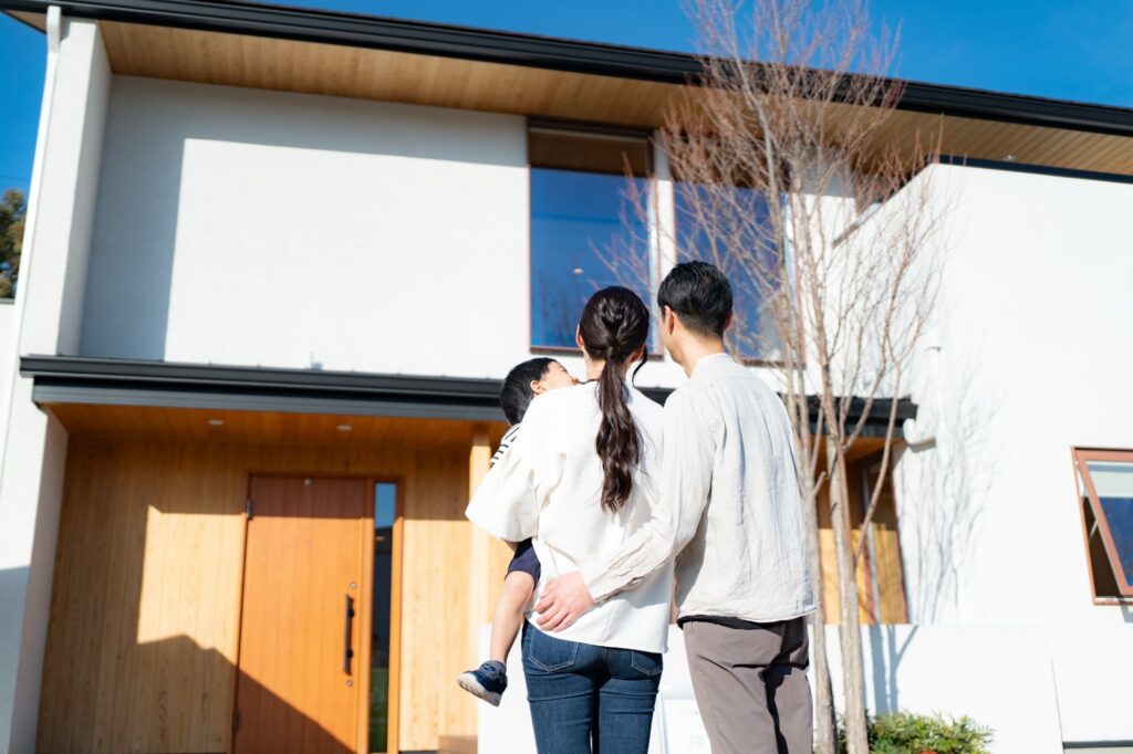完成したマイホームの前に立つ家族
